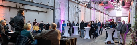 Teilnehmende in einer großen Halle des Industriehofs